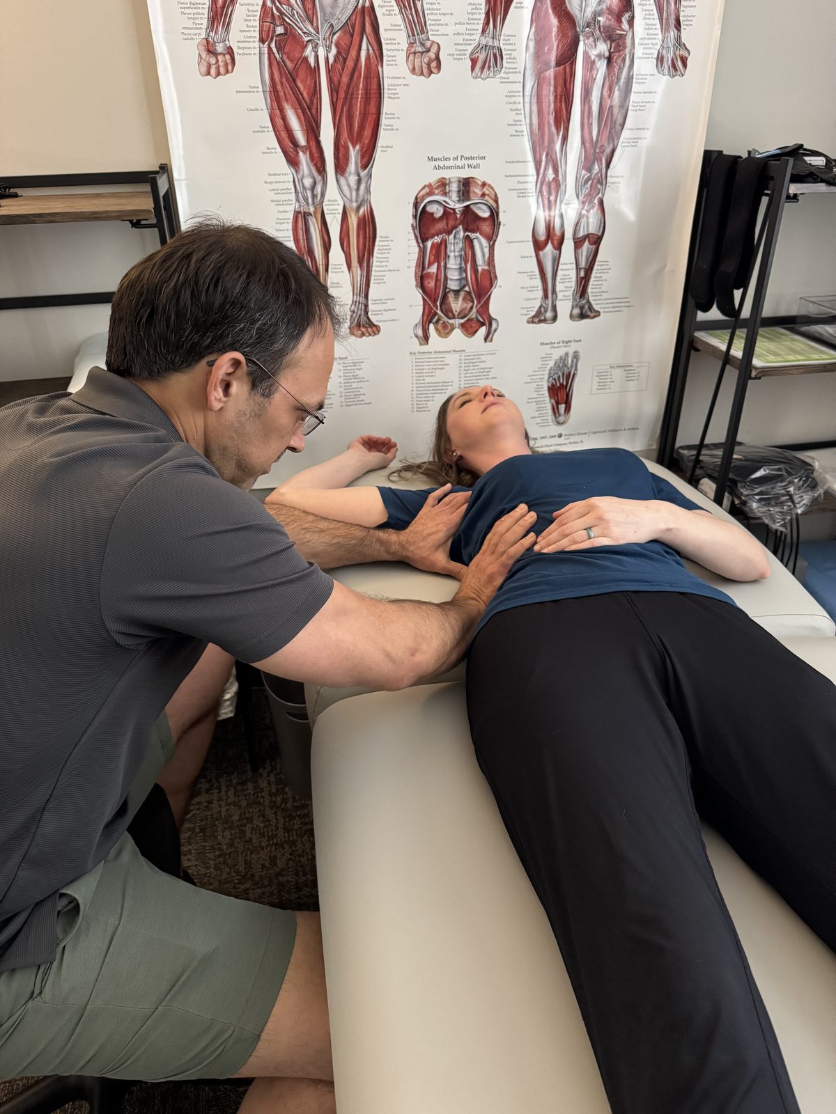 Two Lorenz Total Wellness therapists working on a client at the table