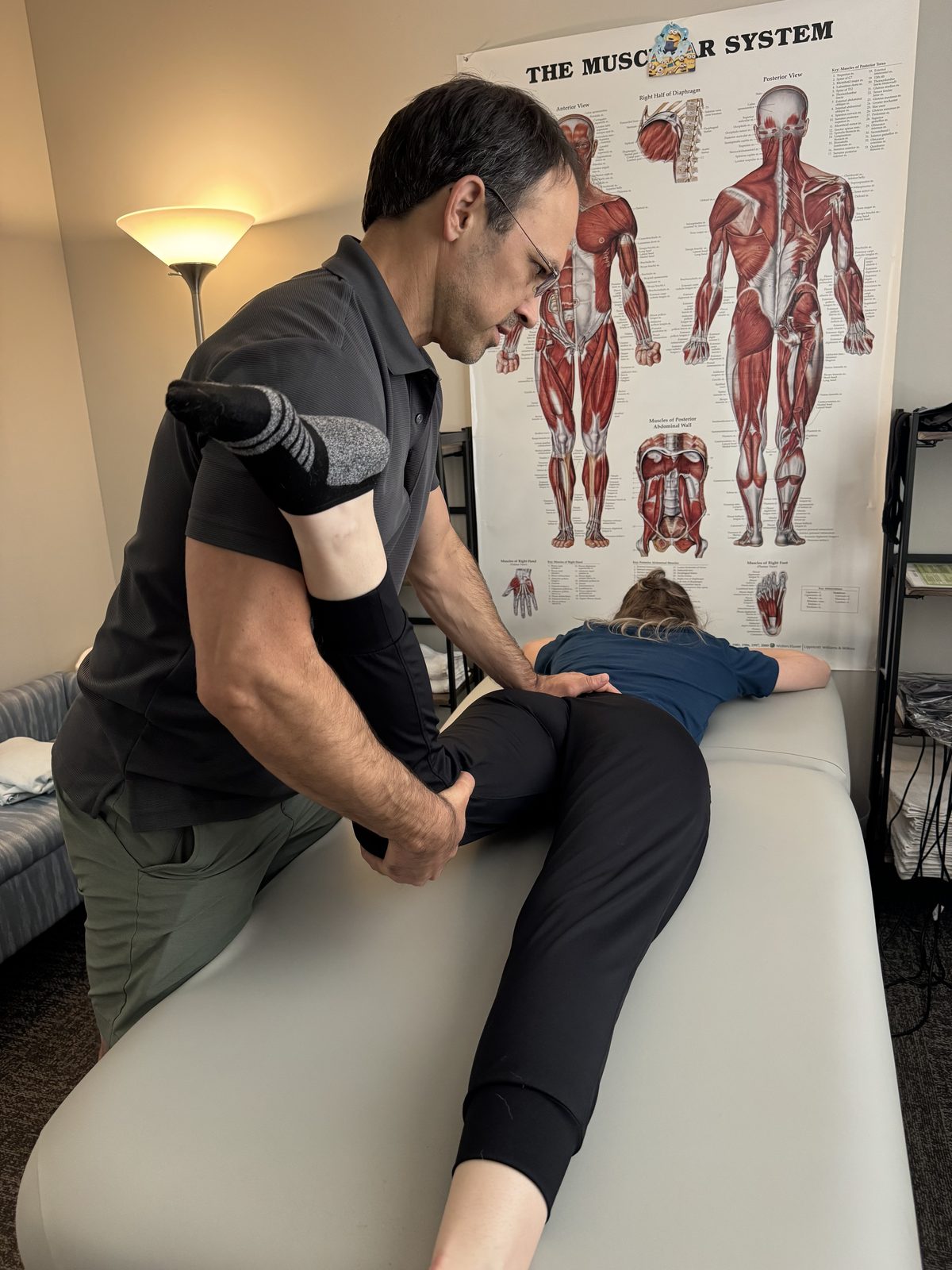 A therapist releasing a client's shoulder in the treatment room